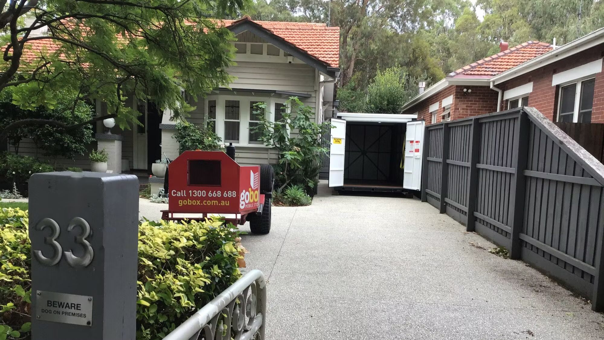 gobox mobile storage unit with doors open on a home driveway, ready to be packed