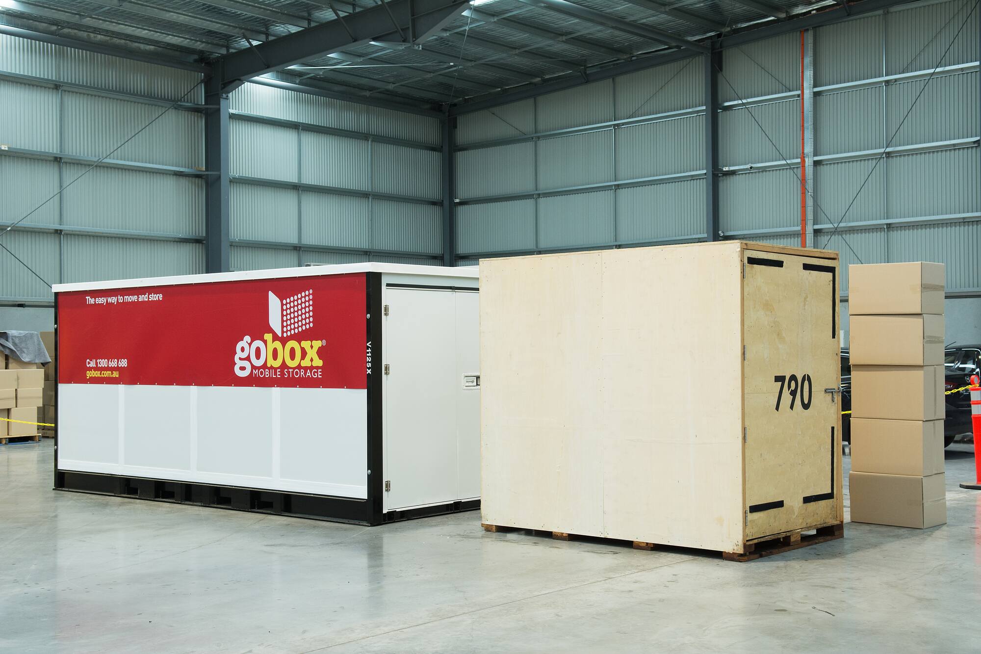 gobox steel storage unit next to a plain wooden crate inside the warehouse
