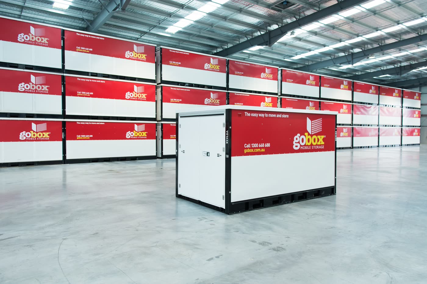 A gobox mobile storage unit in front of rows of stacked units in the gobox warehouse
