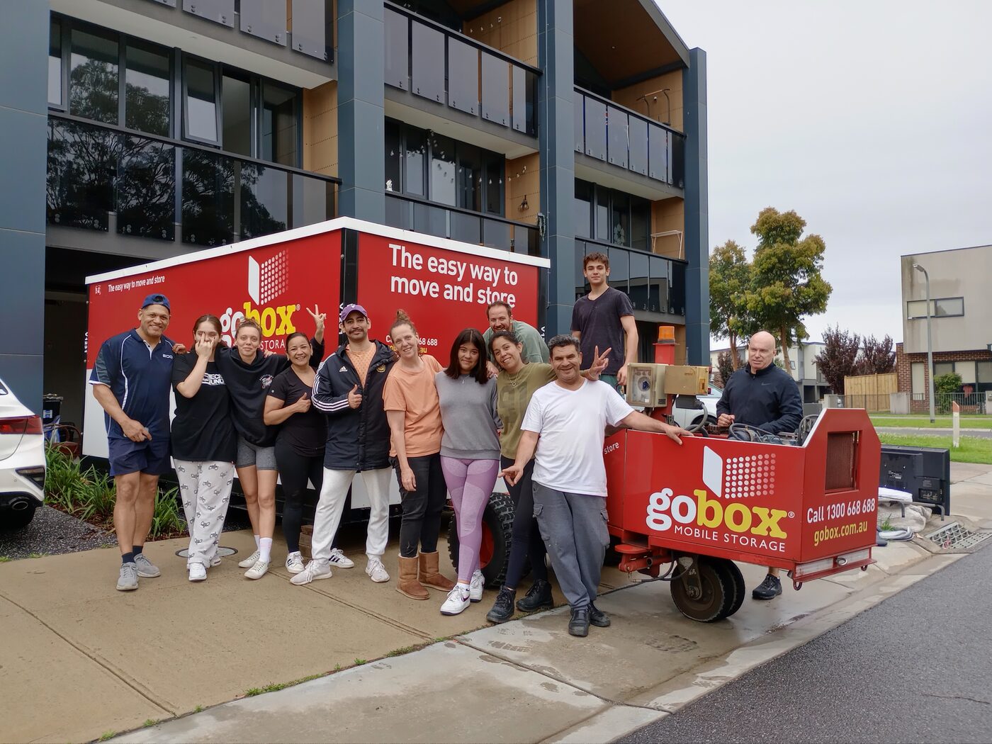 Housemates with their gobox storage unit outside their apartment building
